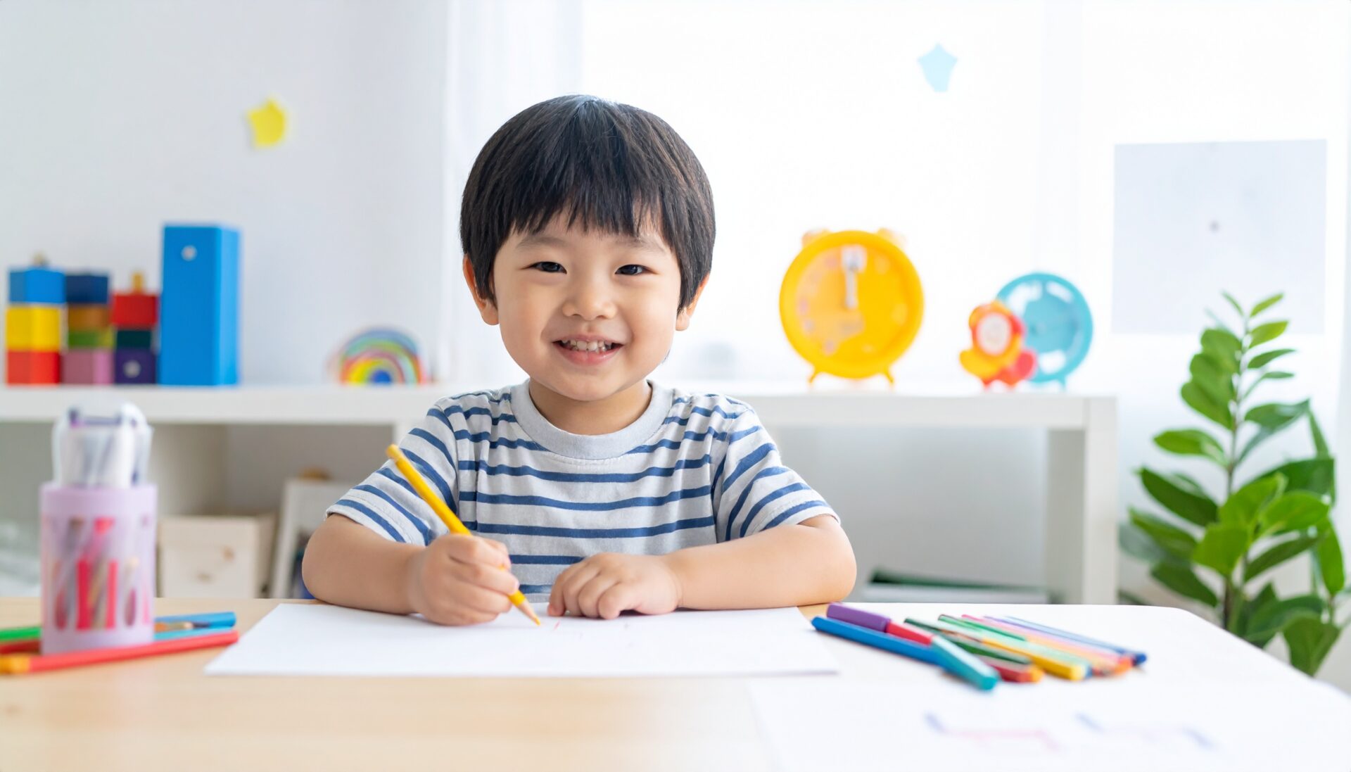 日本人の幼児が夢中で知育プリントに取り組んでいる様子。笑顔で色鉛筆やクレヨンを使いながら机に向かい、達成感にあふれた表情。周囲にはごほうびシールやかわいいタイマーなど、学習を楽しくする工夫が散りばめられている。明るく清潔感のある子ども部屋。