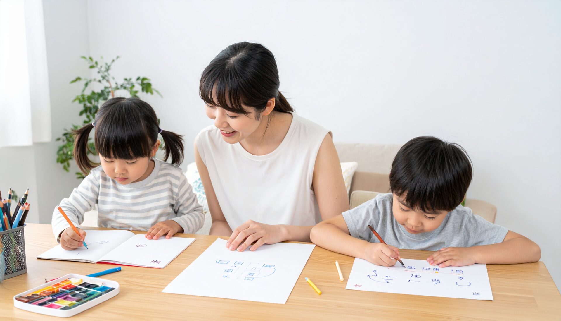 日本人の母親と2人の子ども(幼児と小学生)が、年齢に応じた知育プリントにそれぞれ取り組んでいる家庭の風景。幼児はひらがなや線つなぎ、小学生は漢字や計算のプリントを使用。母親が笑顔で見守る。机の上には年齢別に整理された教材プリントと文房具。明るく整った室内。